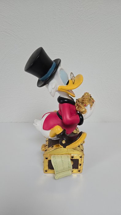 Statue, Disney beeld van Dagobertd Duck op zijn schatkist - 28 cm - Harpiks