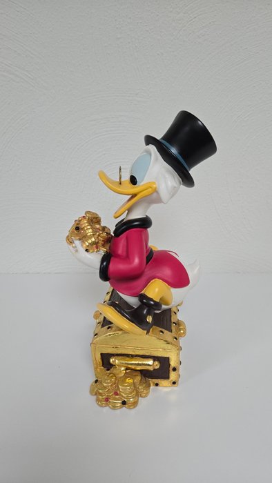 Statue, Disney beeld van Dagobertd Duck op zijn schatkist - 28 cm - Harpiks