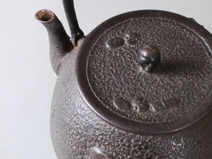 Noh Mask Motifs Kettle 鉄瓶 by Nambu Metalwork 南部堂窯 - Potte - Jern