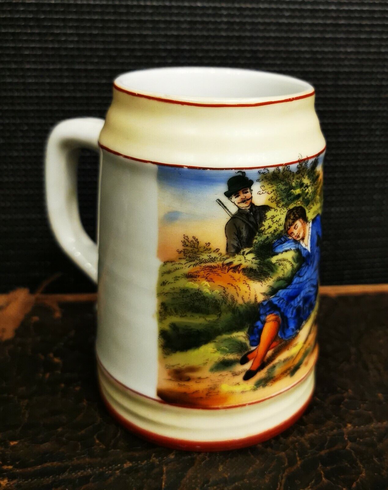 Smaller old porcelain beer mug with romatic scene outside and inside the bottom