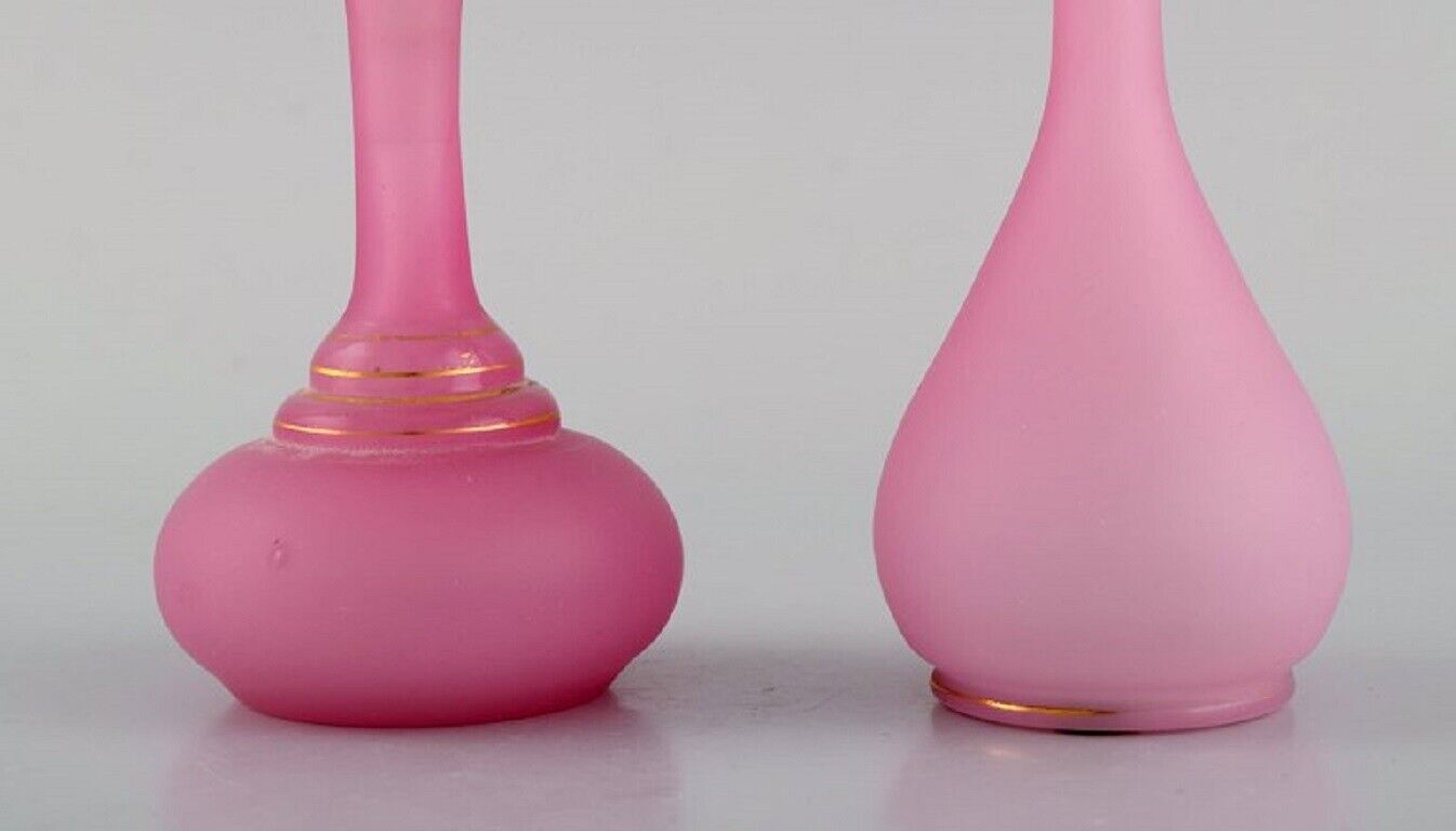 Two vases and two flacons in pink mouth-blown art glass decorated with gold