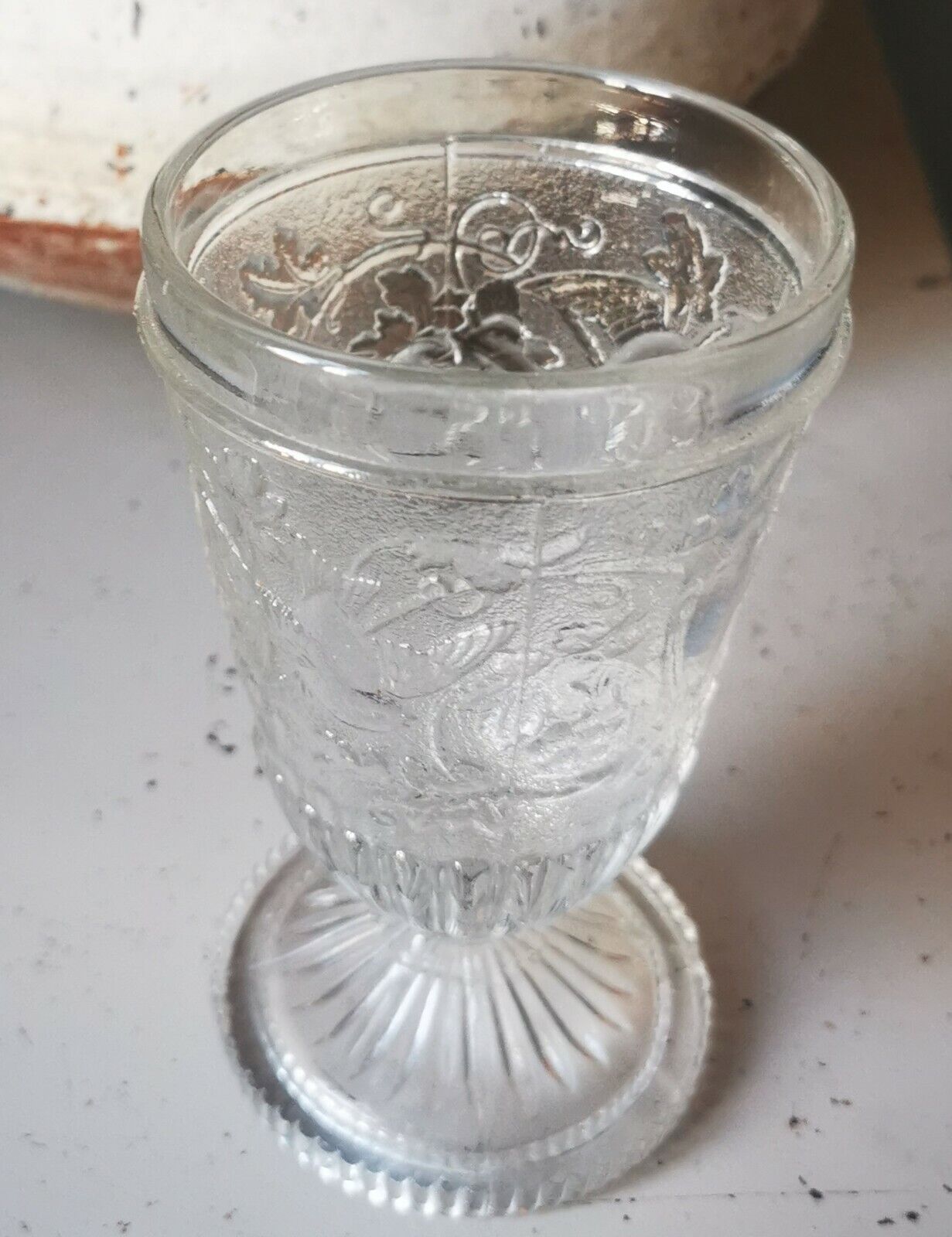 Antique pressed drinking glass with grape and bird decorations from c 1900