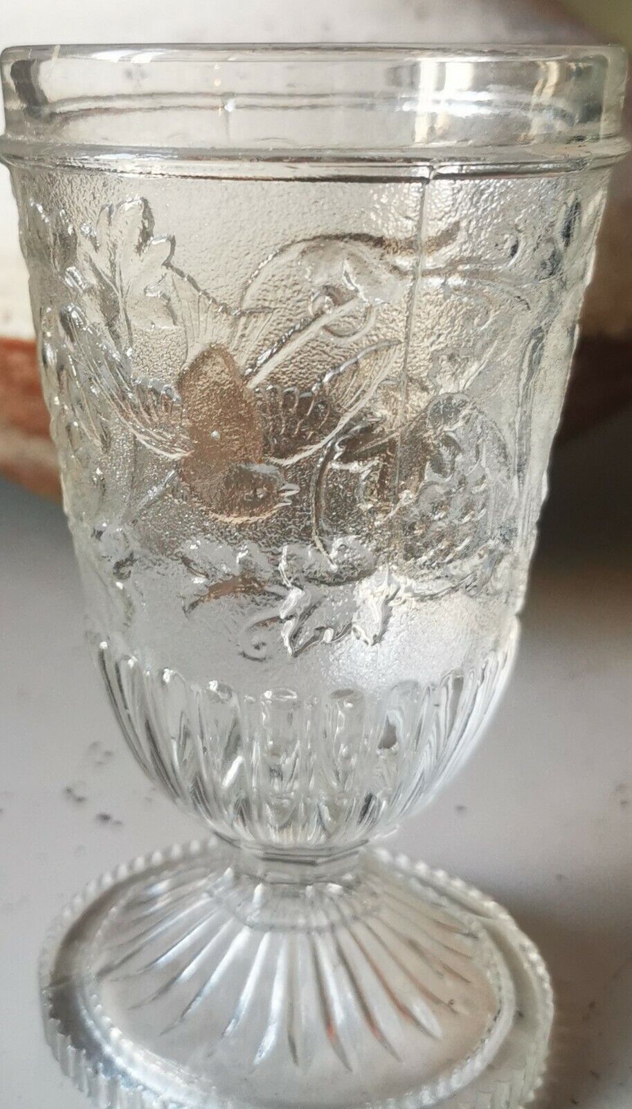 Antique pressed drinking glass with grape and bird decorations from c 1900