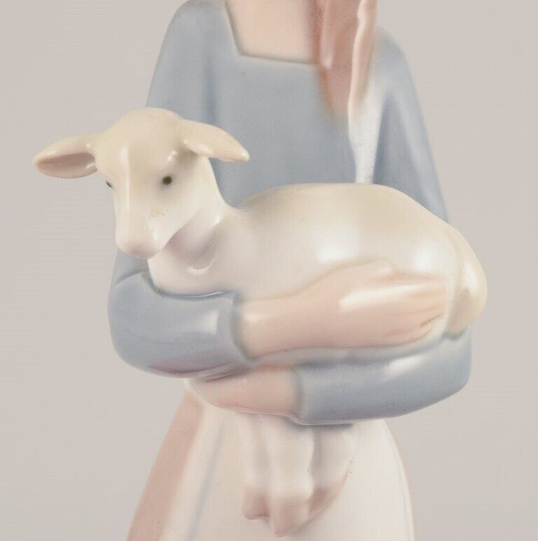 Lladro Spain Porcelain figurine of a standing young woman holding a lamb