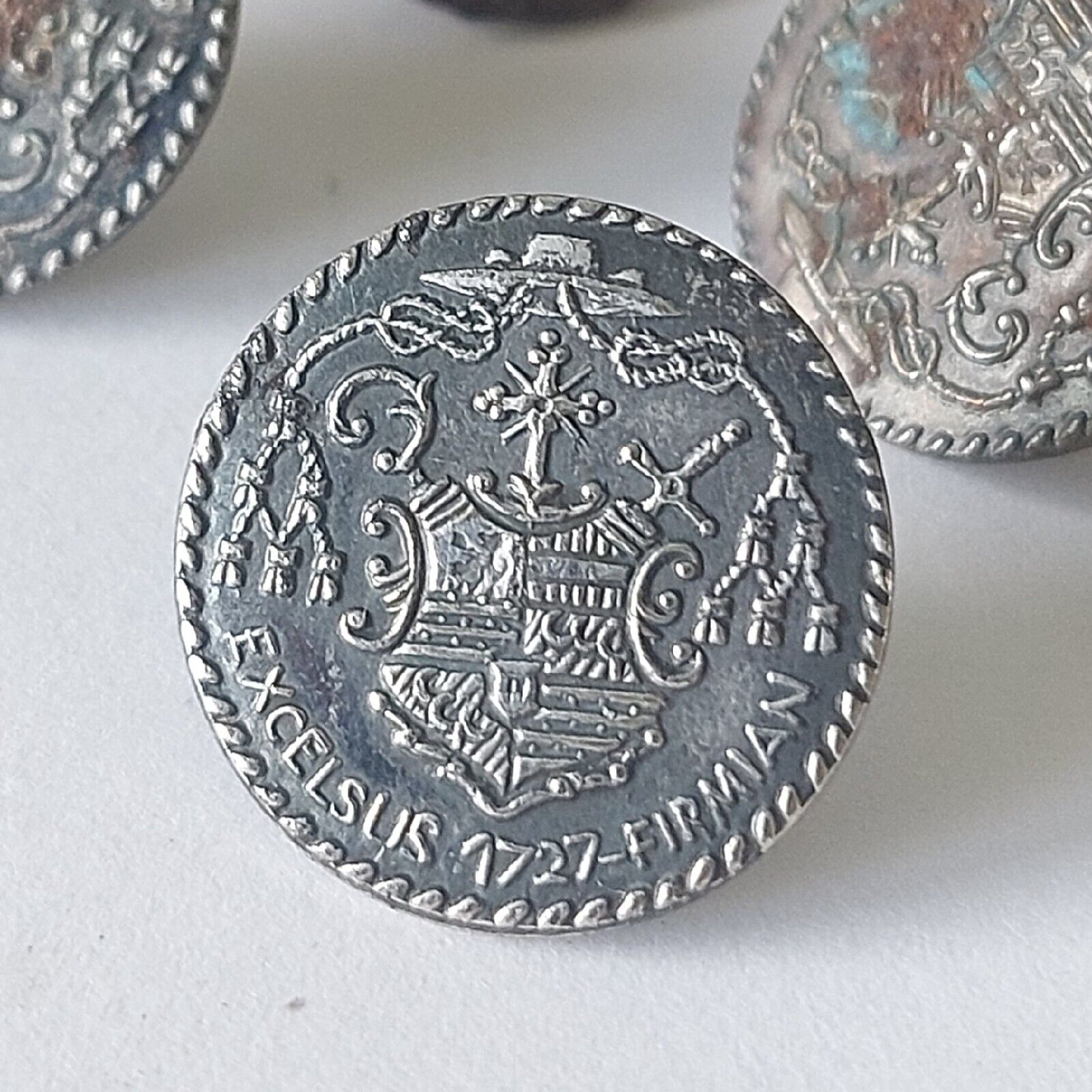 Seven small buttons in metal with noble coats of arms from around 1920