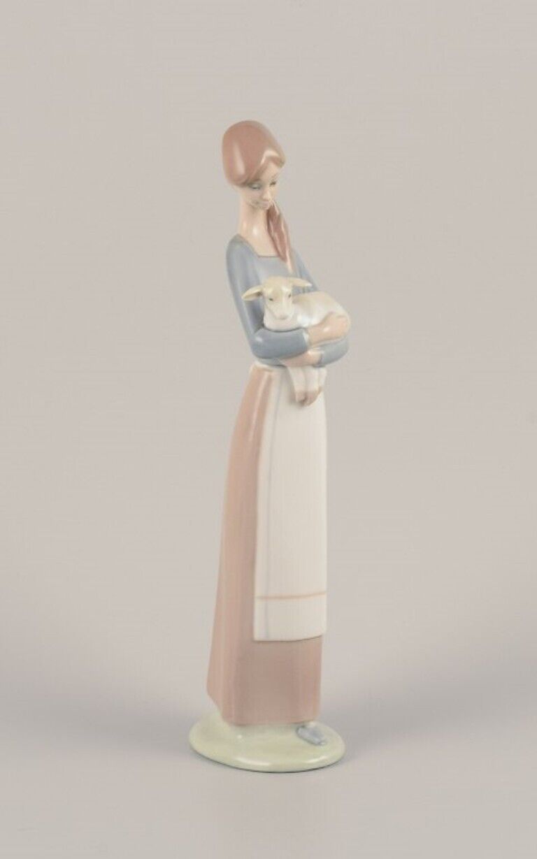 Lladro Spain Porcelain figurine of a standing young woman holding a lamb