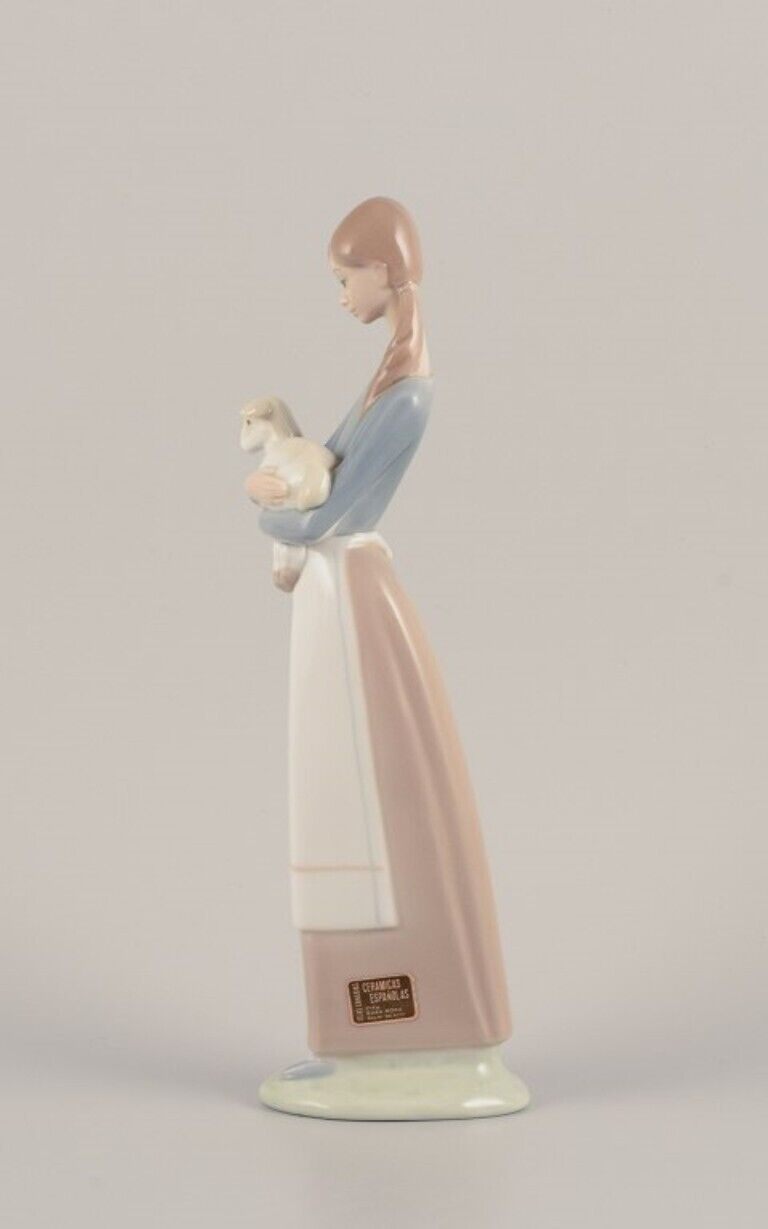 Lladro Spain Porcelain figurine of a standing young woman holding a lamb