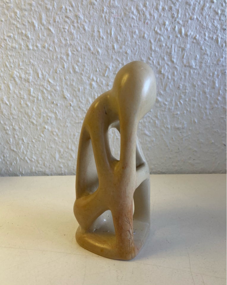 Beige sten skulptur menneske tager