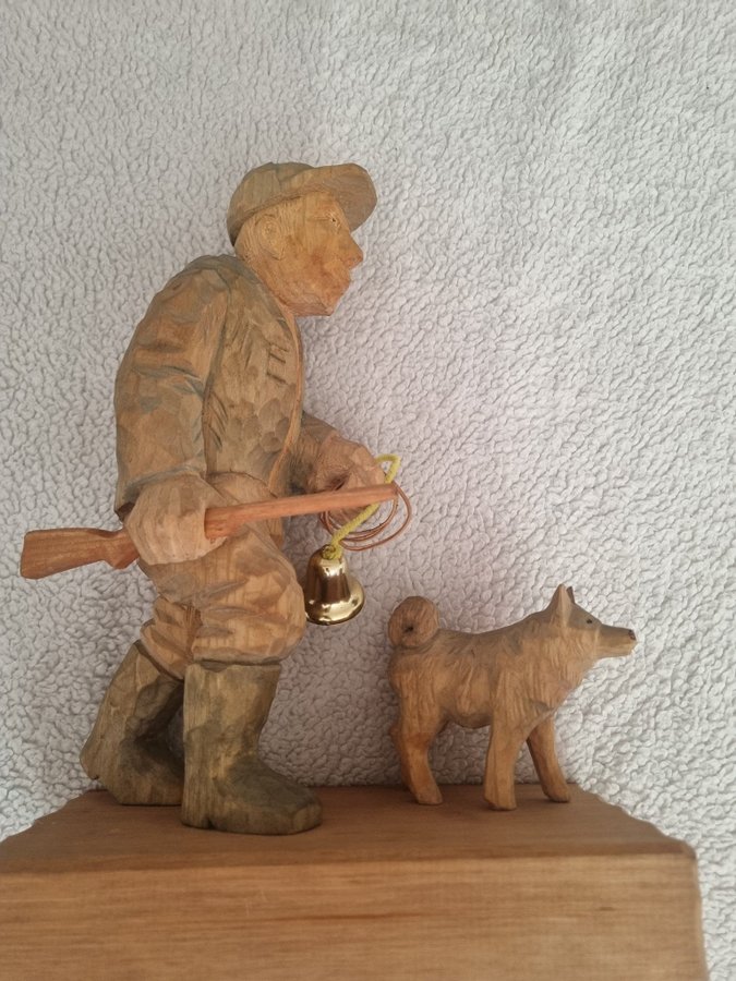 Träskulptur av jägare med hund