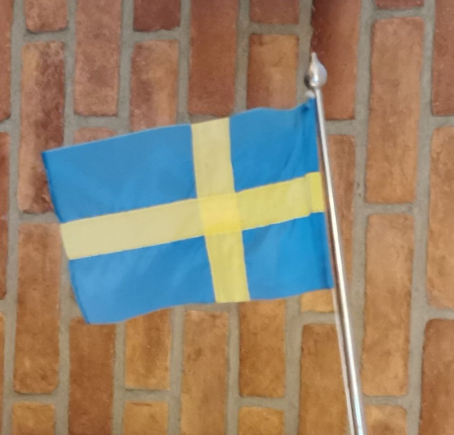 Massiv flaggstång med svenska flaggan.