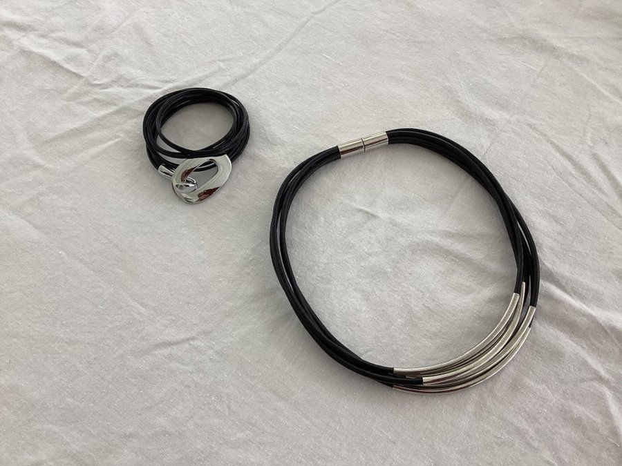 Halsband och armband i konstskinn och silvermetall.