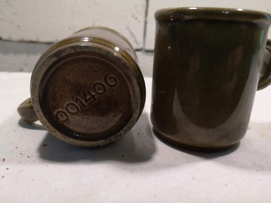 Två små olivgröna koppar i keramik