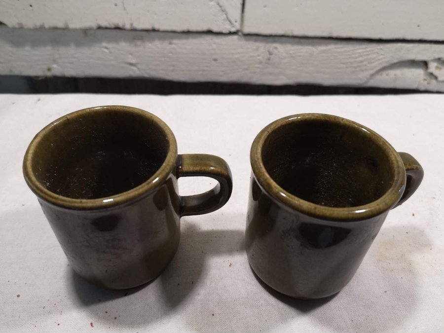 Två små olivgröna koppar i keramik