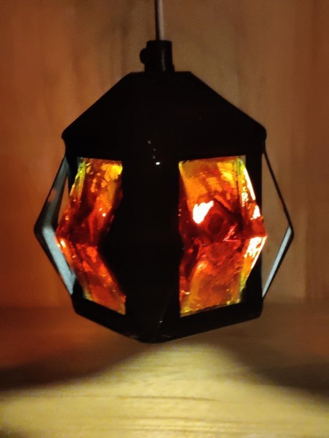 Fönsterlampa, svart metall och rött glas.