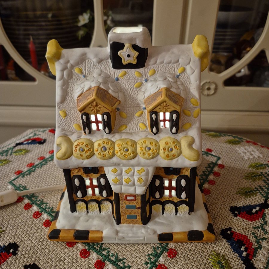 Ett stort fint pepparkakshus ljuslykta i keramik med elbelysning