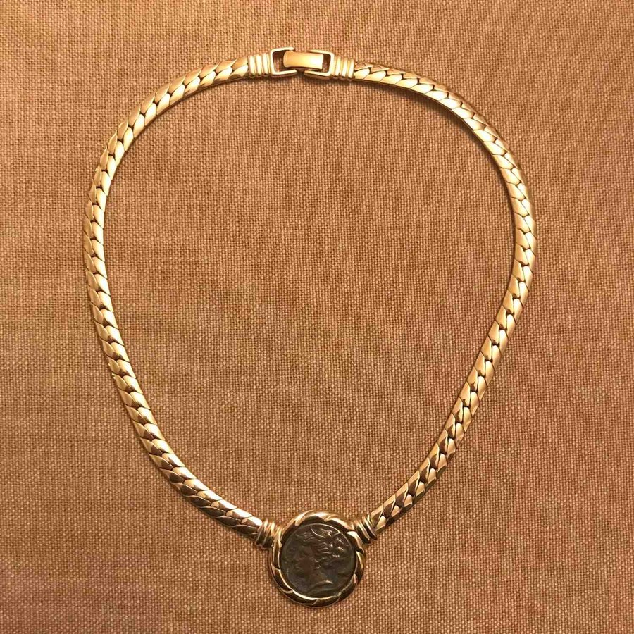 Halsband i guldfärgad metall myntliknade fast berlock