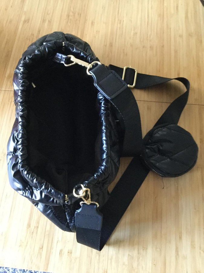 Tuff svart handväska i typ "täckjacketyg" bygelöppning
