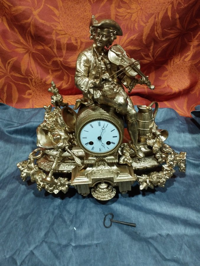 Antique gilt regule table clock: violinist with pendulum bell and key