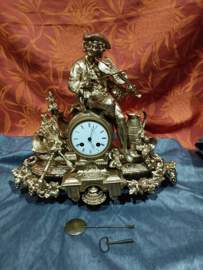 Antique gilt regule table clock: violinist with pendulum bell and key