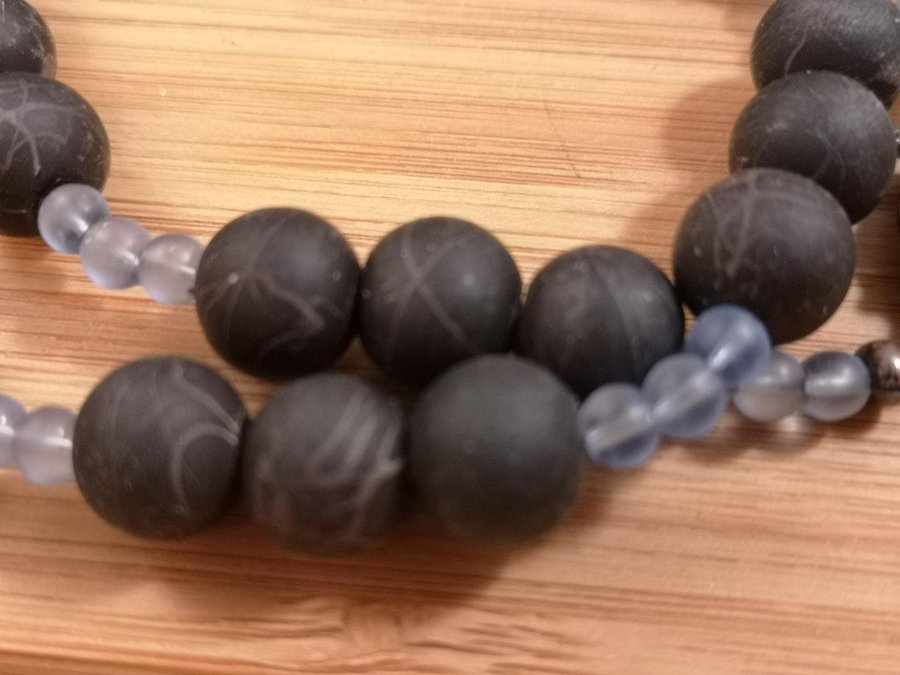 ett spännande halsband i mat svart och ljus blå