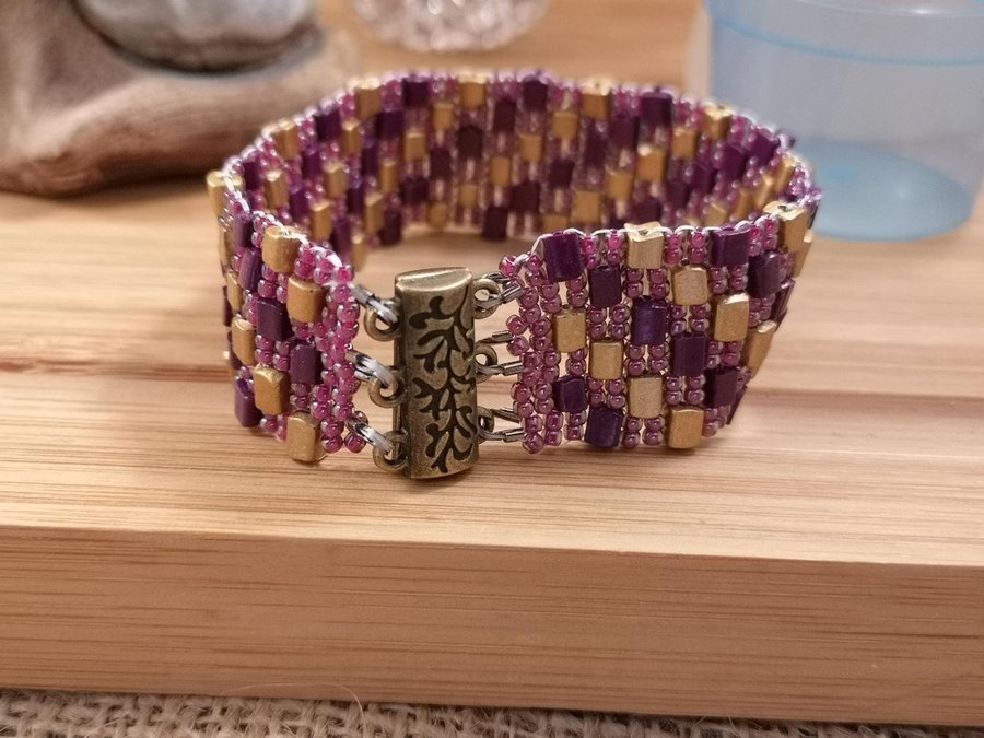 ett Peyote armband I aubergine och guld färg