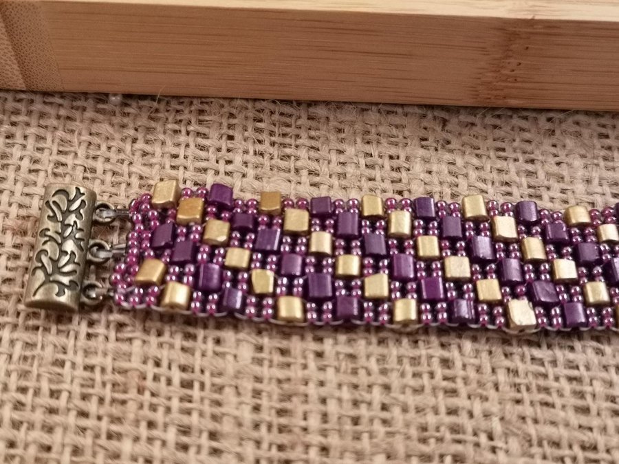 ett Peyote armband I aubergine och guld färg