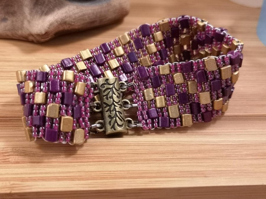 ett Peyote armband I aubergine och guld färg