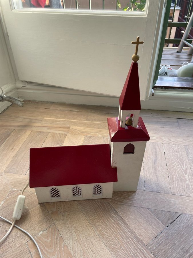 Liten kyrka med ljus och klockspel