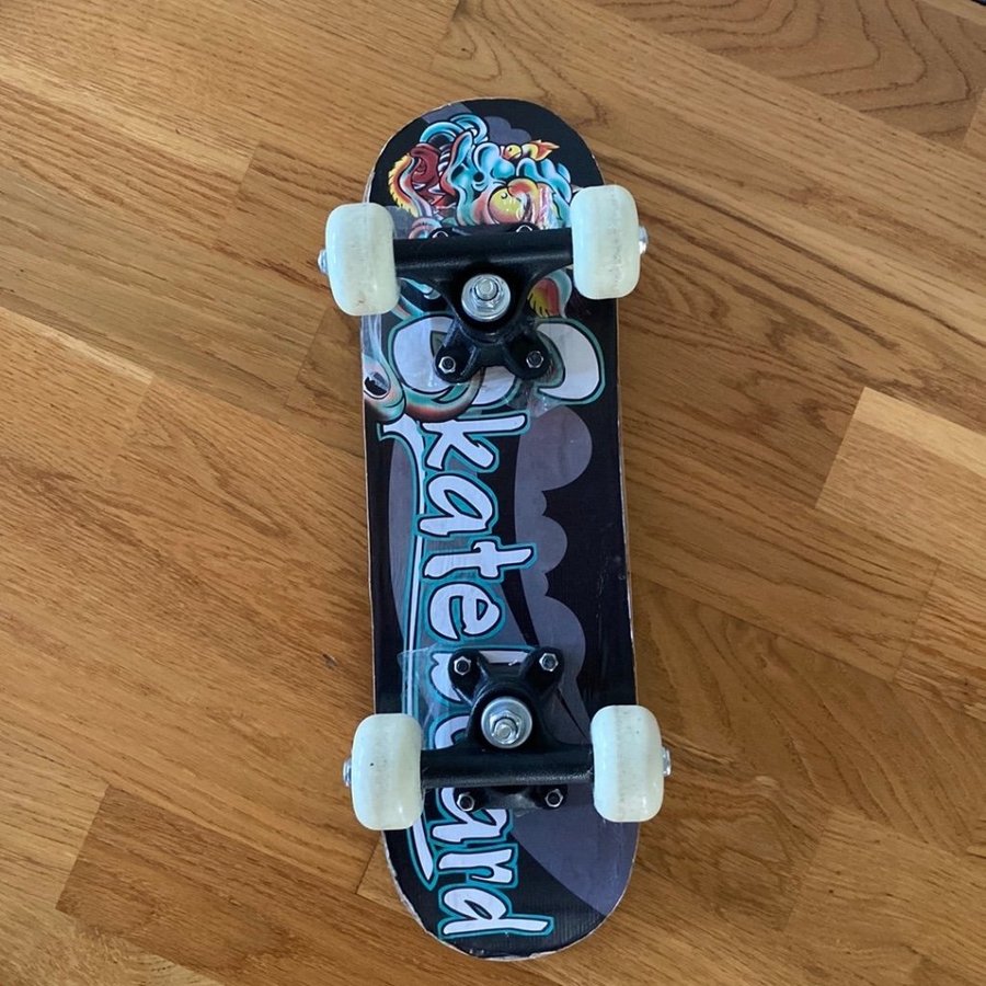 Skateboard med drakmotiv längd 43 cm