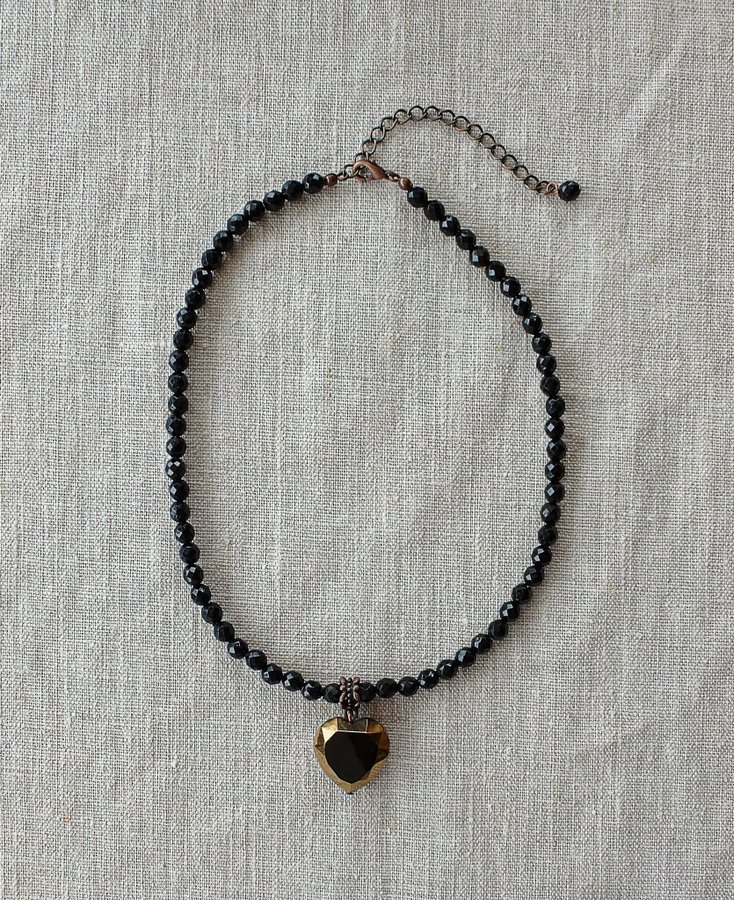 Nytt halsband med små svarta fasettslipade stenar och ett hängande hjärta