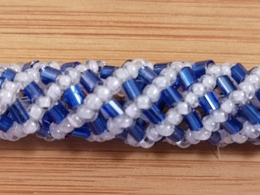 Armband bestående av vita seed och korta toggle (stav) pärlor