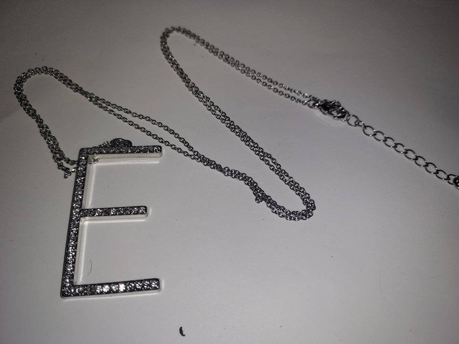 Halsband Hänge E i " diamanter" L 45 cm Silvrig länk i metall L 78 cm