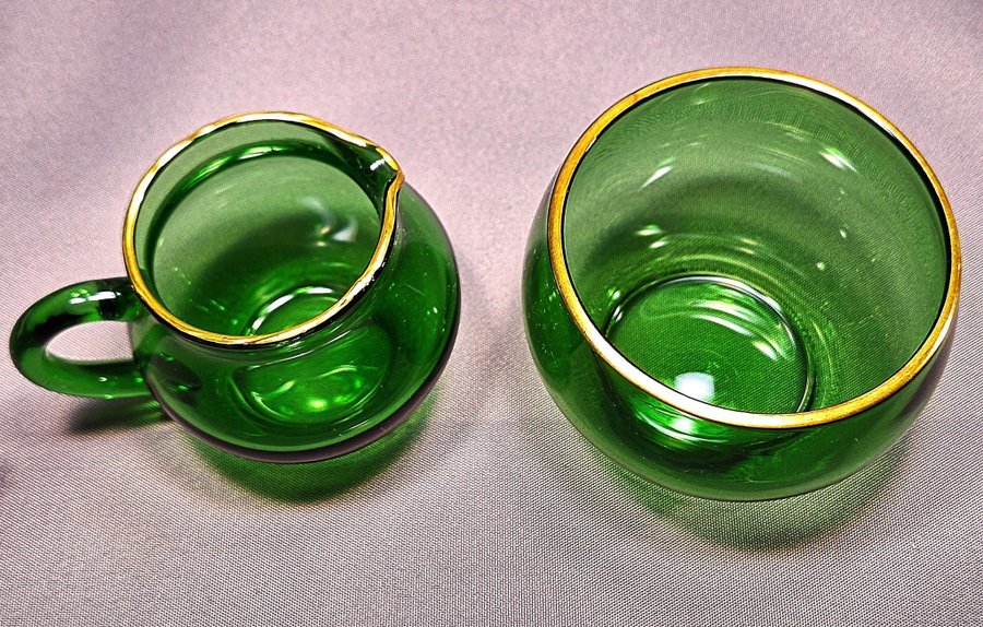 Fint set med munblåst gräddkanna och sockerskål av grönt glas och guldkant