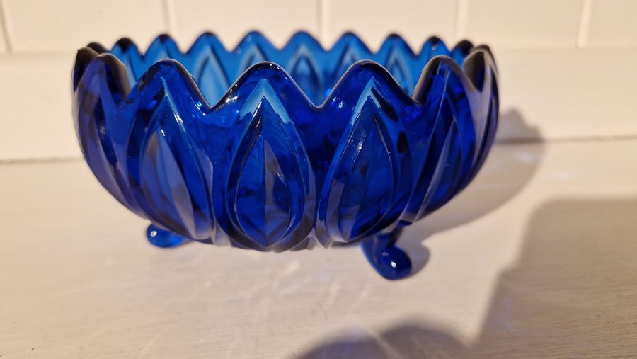 Vacker glas skål med ben i blått