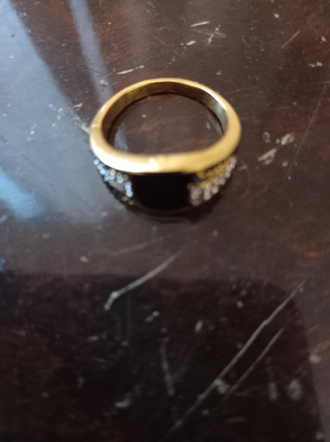 En ring av stål guldfärgad med svart sten 20mm ny