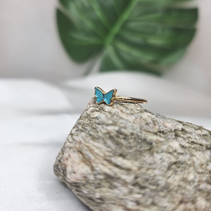 Vacker ring med blå fjäril