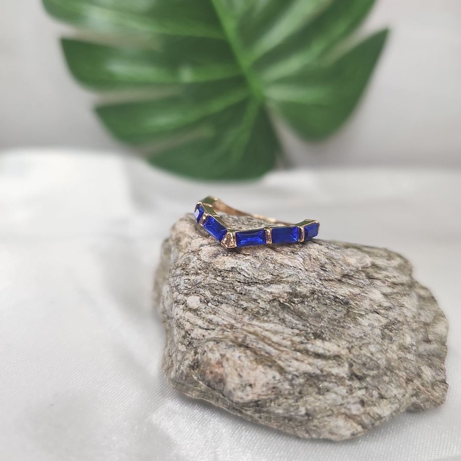 Underbar v-formad glittrande ring med blå stenar