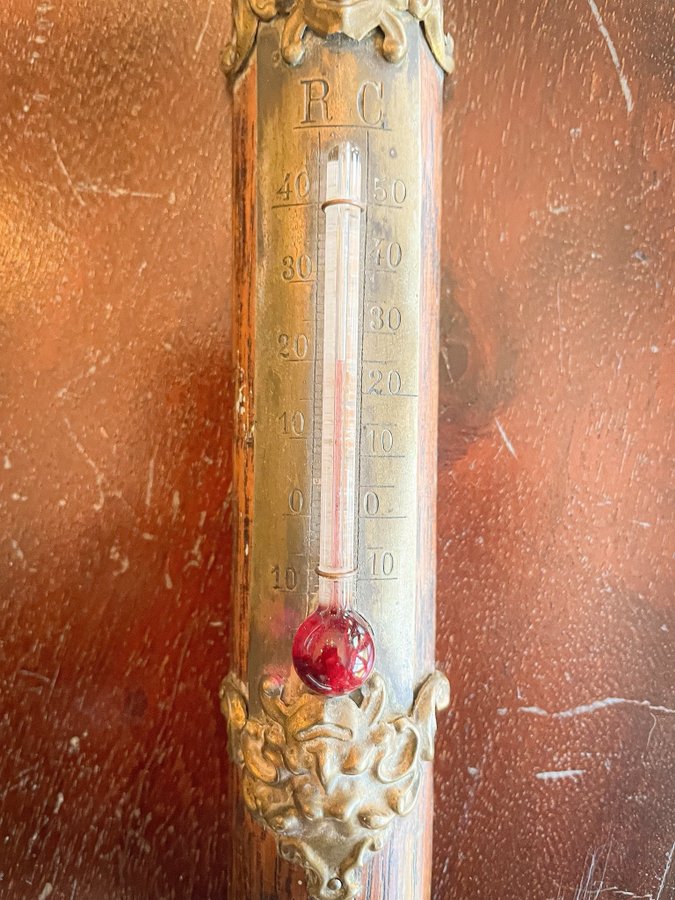 En äldre termometer i from av en yxa Mässing trä kuriosa