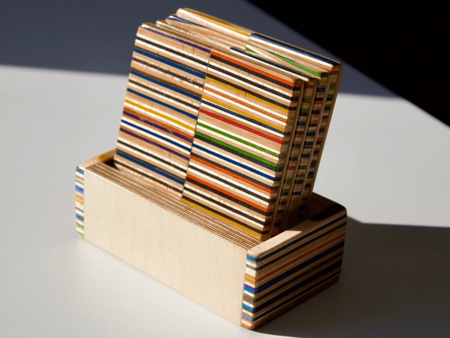 Set of four coasters with holder made from recycled skateboards