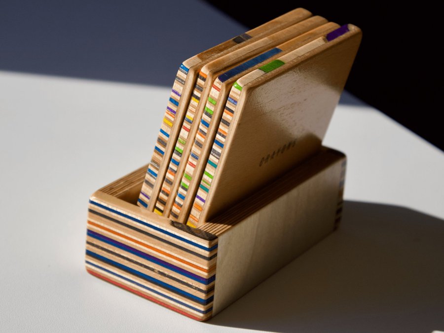 Set of four coasters with holder made from recycled skateboards