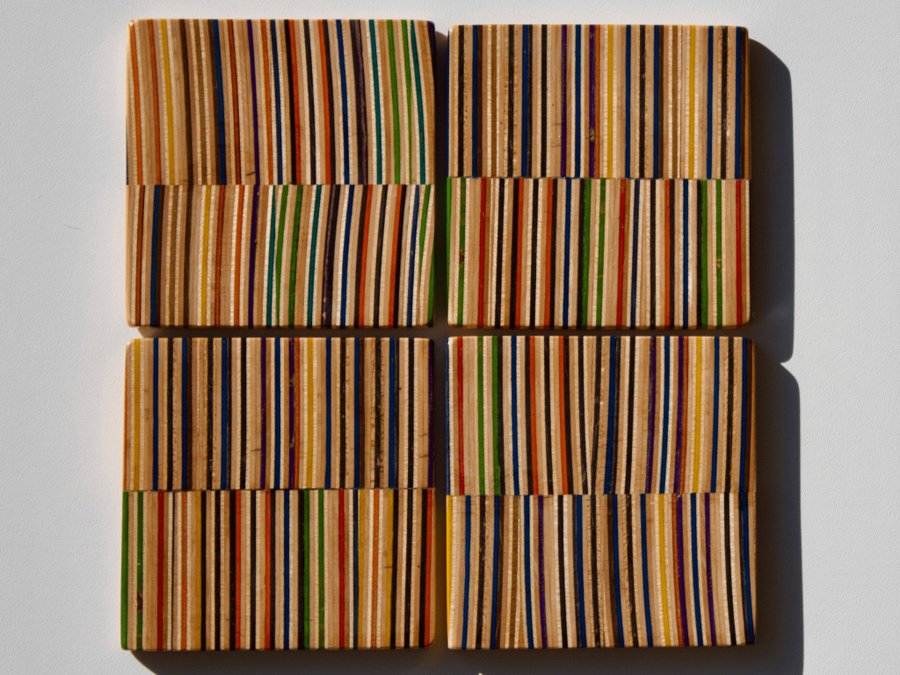 Set of four coasters with holder made from recycled skateboards