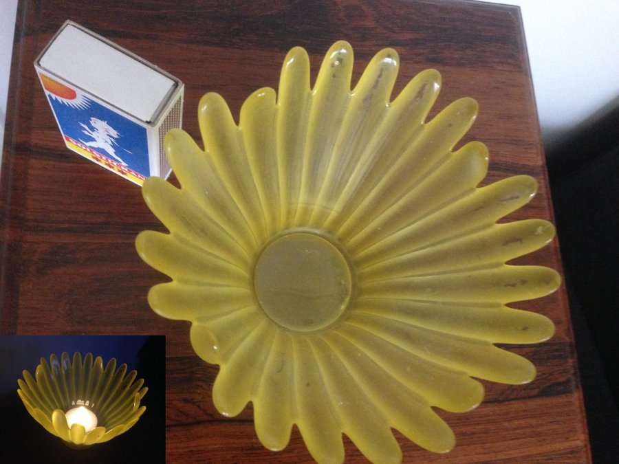 En ljushållare en i form av skål i gul färg