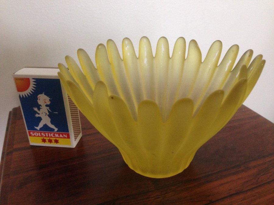 En ljushållare en i form av skål i gul färg