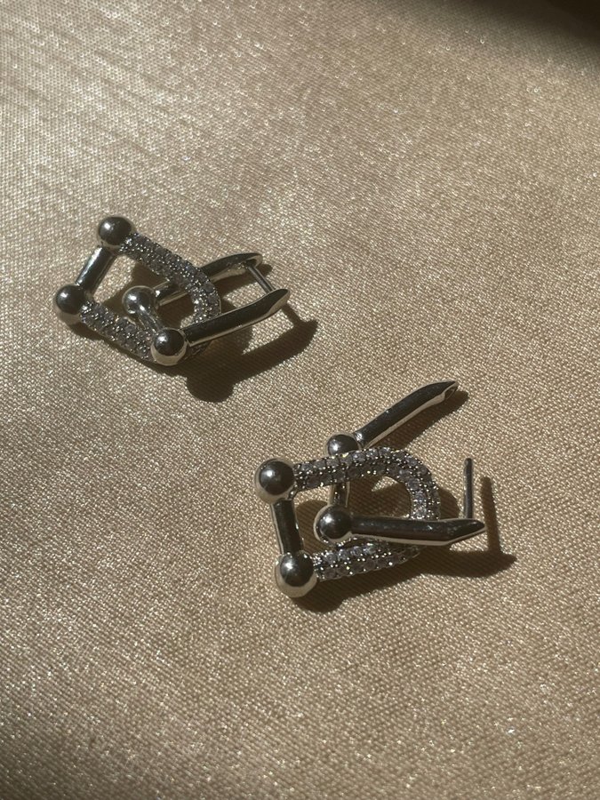 Minimalistiska silverfärgade örhängen i länkdesign
