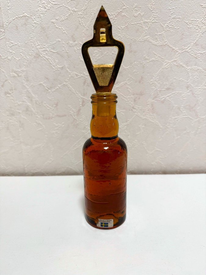 En retro flasköppnare i glas från Lindshammars glasbruk