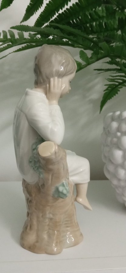 Porslinfigur pojke på stubbe med en bok i knä Lladro Spain