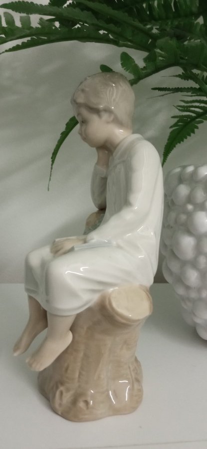 Porslinfigur pojke på stubbe med en bok i knä Lladro Spain