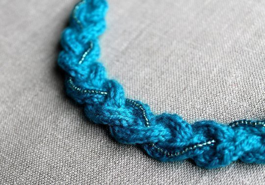 Stickat blått halsband med pärlor