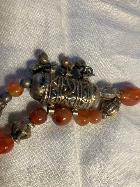 Dekorativt halsband med orangefärgade stenar och metall Längd: ca 53 cm