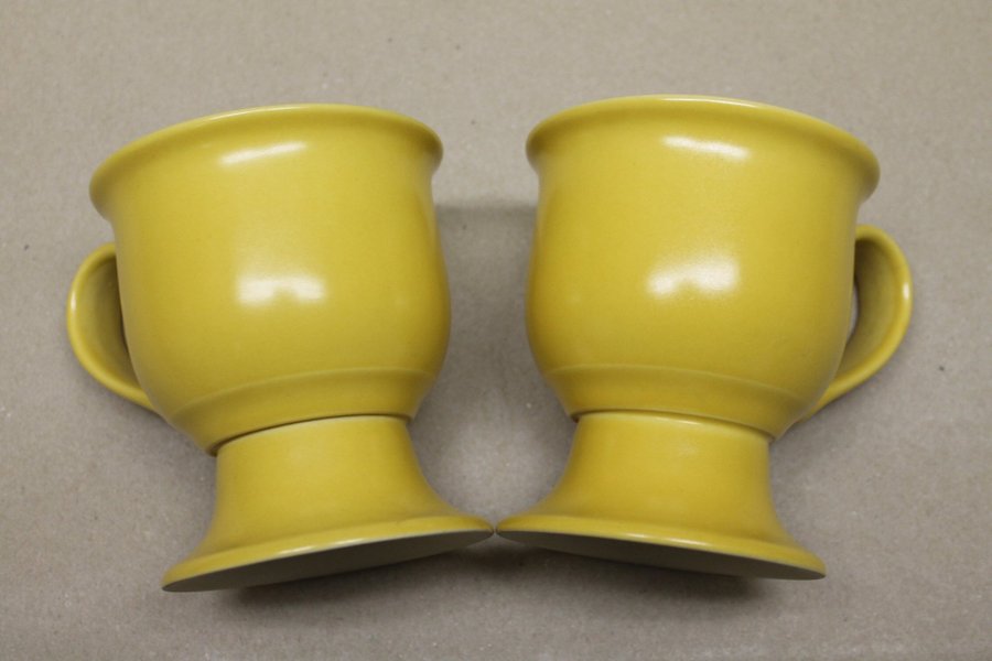 Två gula Muggar på fot från Höganäs keramik